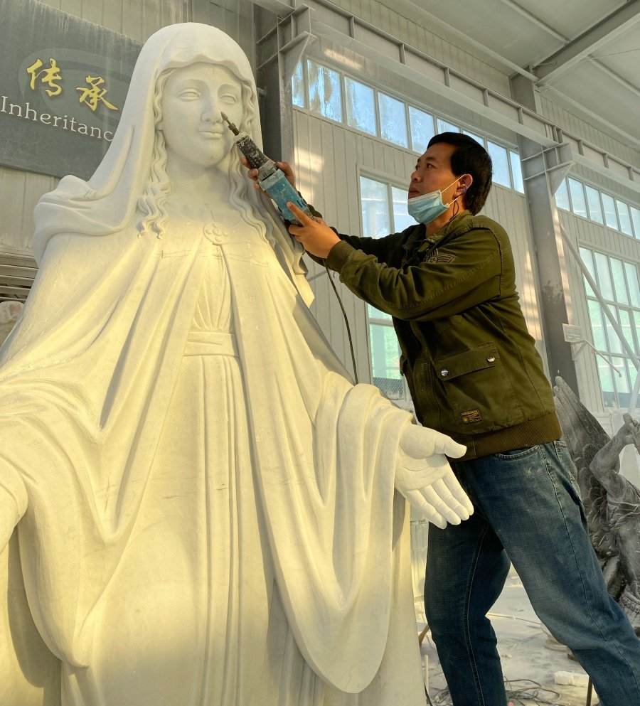 A craftsman carving details into a marble statue