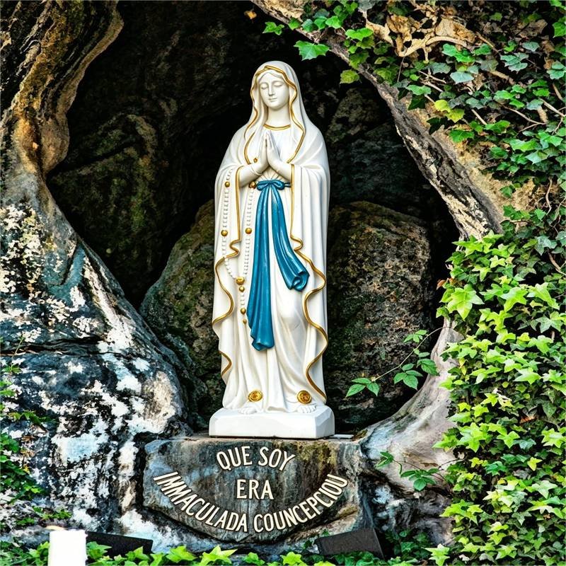 Our Lady of Lourdes statue with yellow roses on feet and grotto base