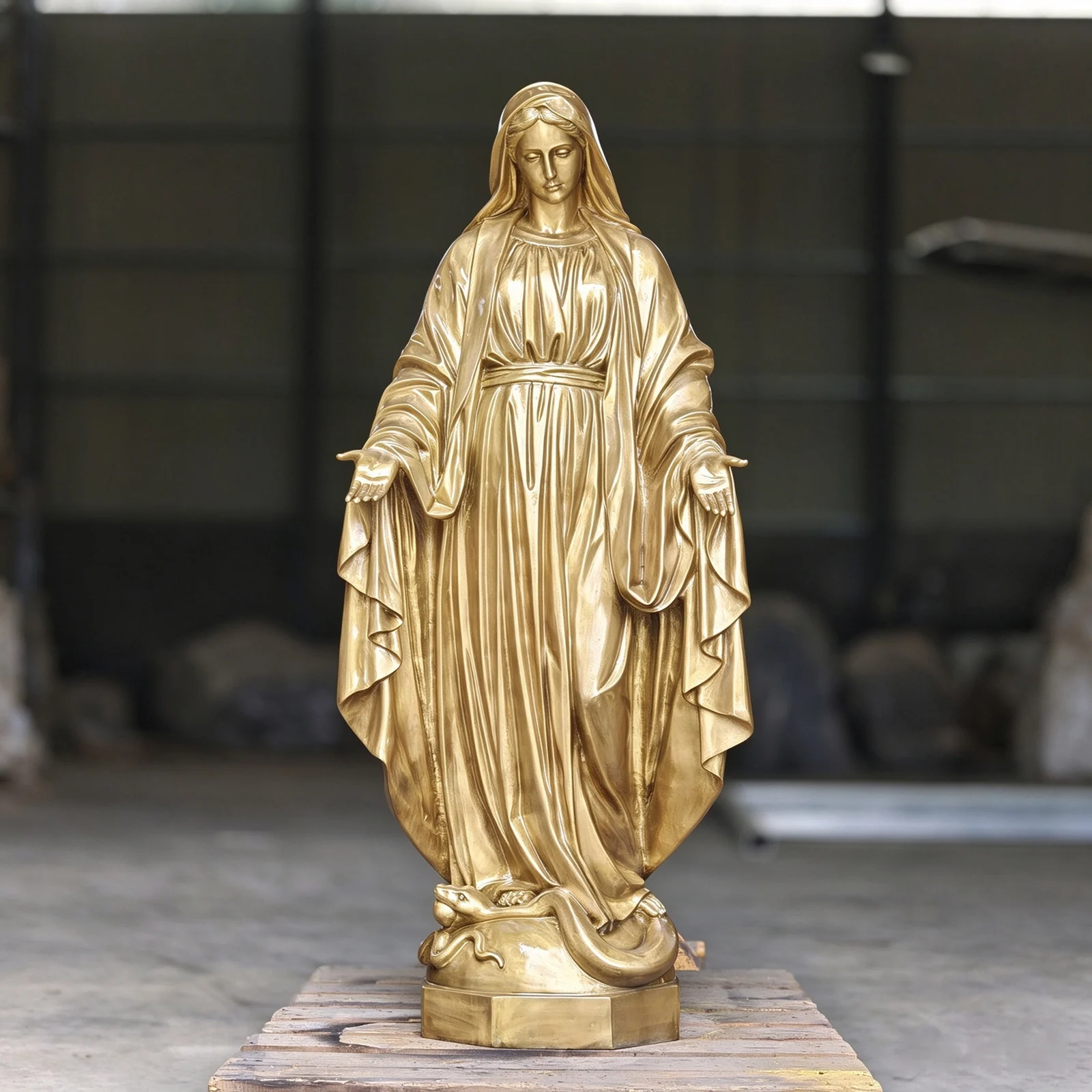 Gold-tone Virgin Mary statue in a workshop