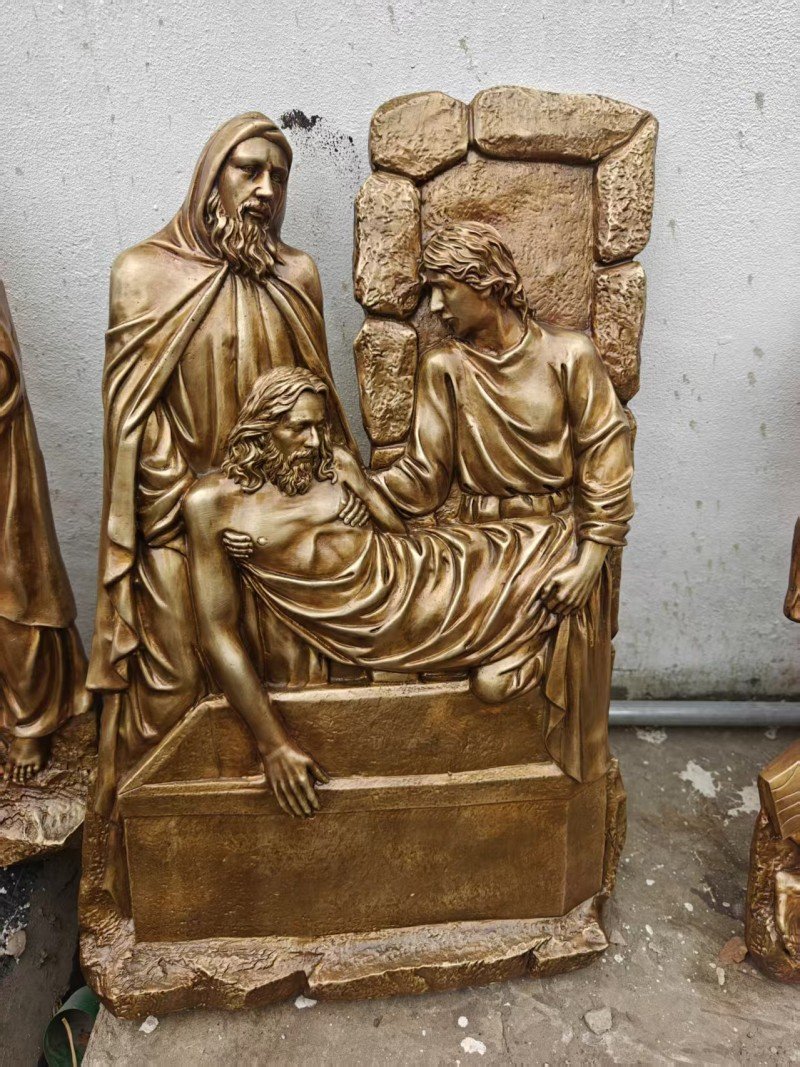 Gold-colored relief, Station XIV — Jesus is laid in the tomb